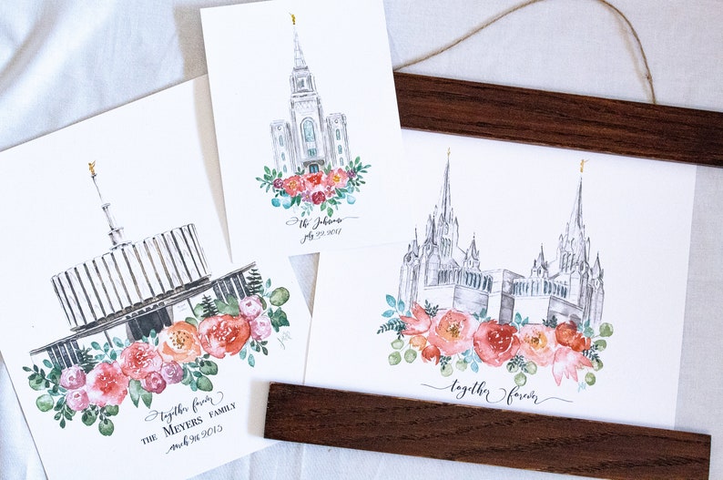 May include: Three watercolor paintings of different temples with floral wreaths and personalized text. The first painting is of the Salt Lake Temple with the text "Together Forever, The Meyers Family, March 24, 2013". The second painting is of the St. Johns Temple with the text "St. Johns, July 22, 2017". The third painting is of the Provo Temple with the text "Together Forever".