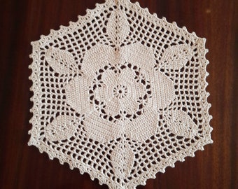 May include: A white crocheted doily with a delicate floral design. The doily is circular and has a scalloped edge.