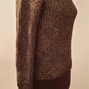 May include: A brown and gold knitted sweater with a textured pattern. The sweater is on a mannequin.