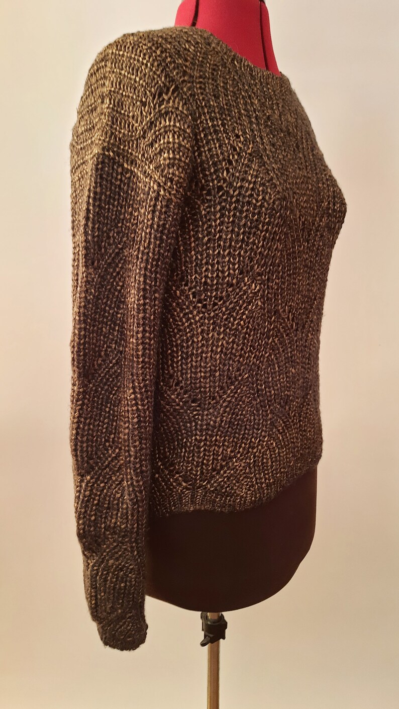 May include: A brown and gold knitted sweater with a textured pattern. The sweater is on a mannequin.