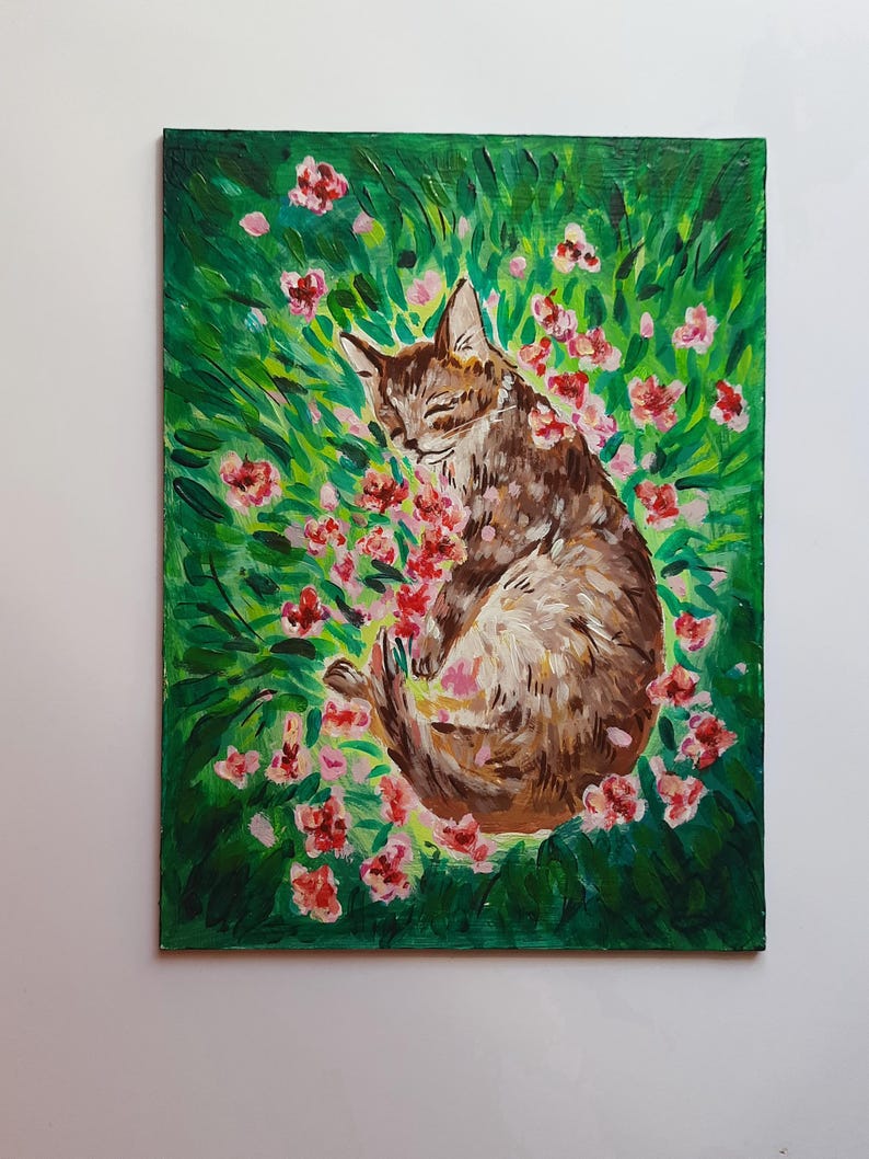 Puede incluir: Una pintura de un gato atigrado marr&oacute;n durmiendo en un campo de hierba verde y flores rosas.