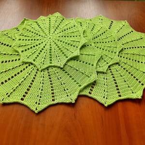 May include: Three green crocheted doilies with a starburst pattern.