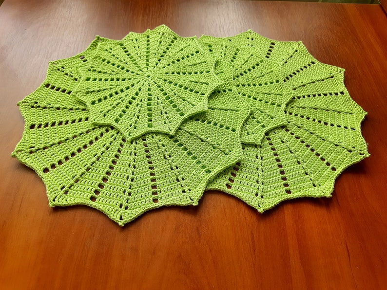 May include: Three green crocheted doilies with a starburst pattern.