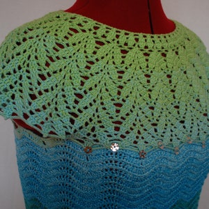 May include: A crocheted top with a green and blue ombre design. The top has a scalloped neckline and is decorated with sequins.