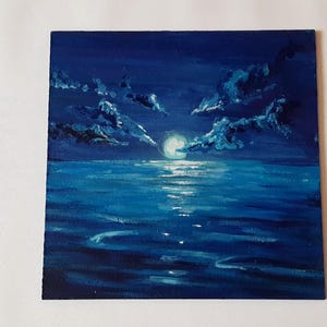 May include: A painting of a moonlit seascape with dark blue clouds and a bright white moon reflecting on the water.