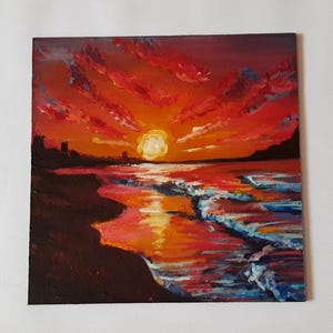 May include: A painting of a sunset over the ocean. The sky is a vibrant orange and red, with clouds painted in shades of pink and purple. The sun is setting in the distance, casting a golden glow on the water. The waves are crashing on the shore, creating a foamy white edge.