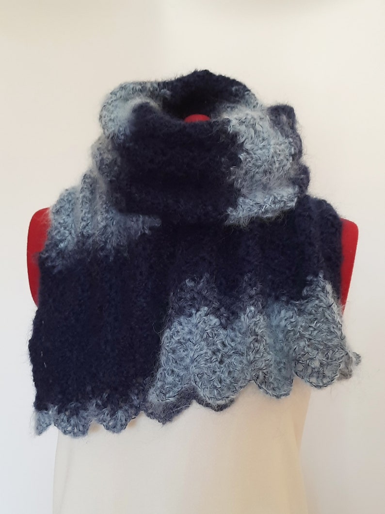 May include: A blue and gray crocheted infinity scarf with a scalloped edge.