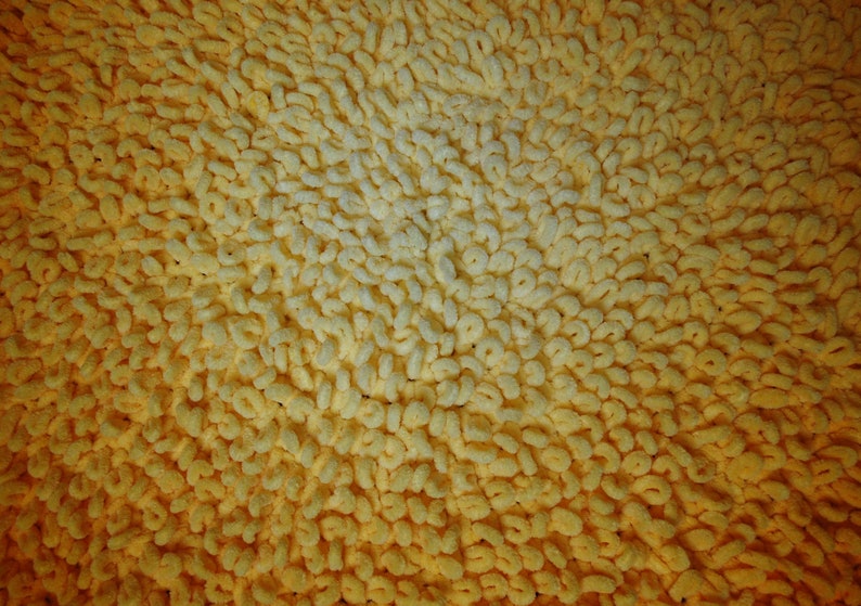 May include: Close-up of a yellow bath mat with a textured surface. The mat is made of soft, looped fibers that create a plush and absorbent surface.