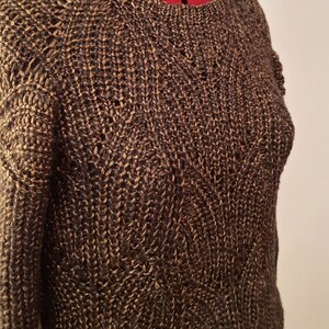 May include: A brown and gold knitted sweater with a cable knit pattern.