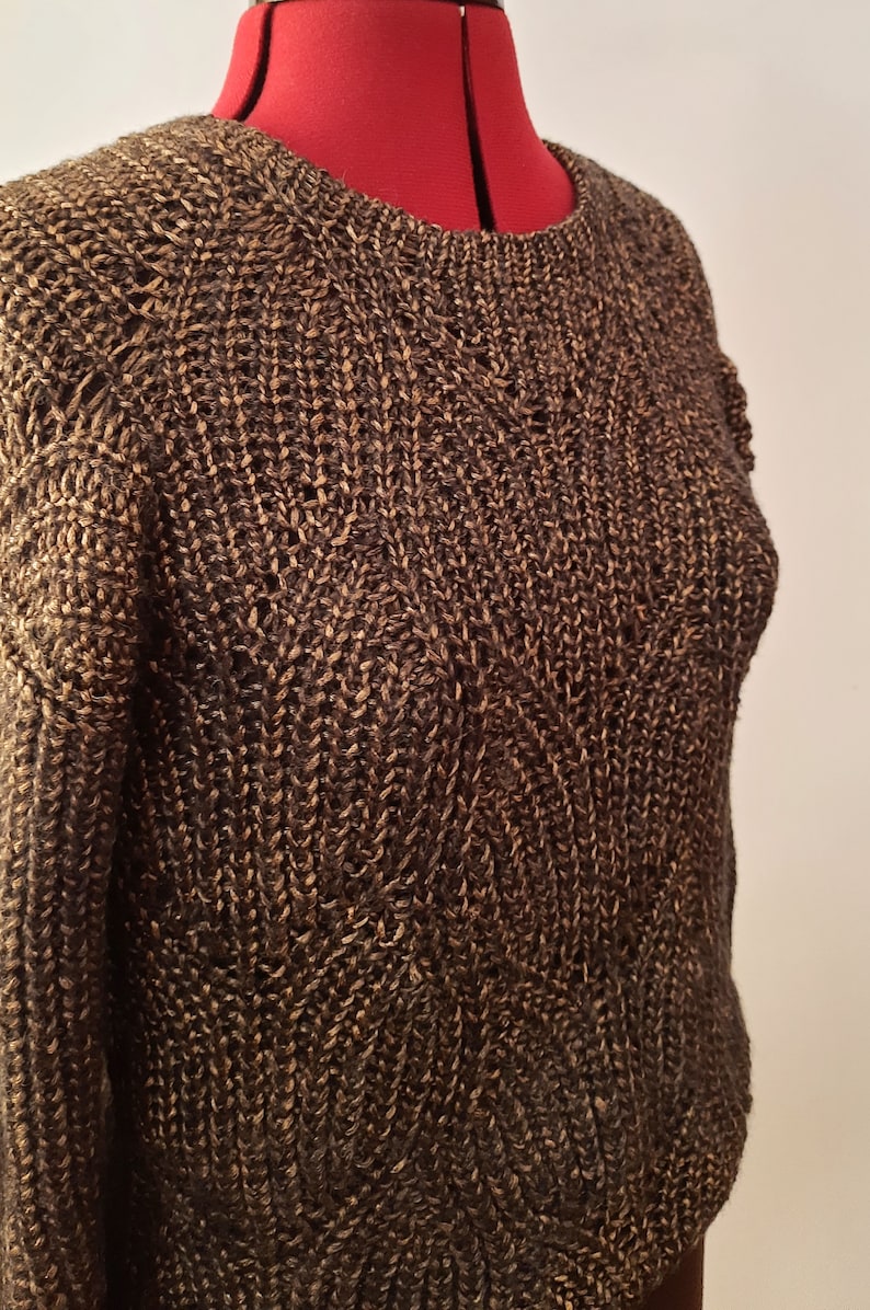 May include: A brown and gold knitted sweater with a cable knit pattern.