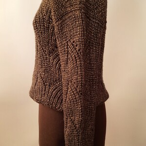 May include: A brown knitted sweater with a textured pattern. The sweater is on a dress form.