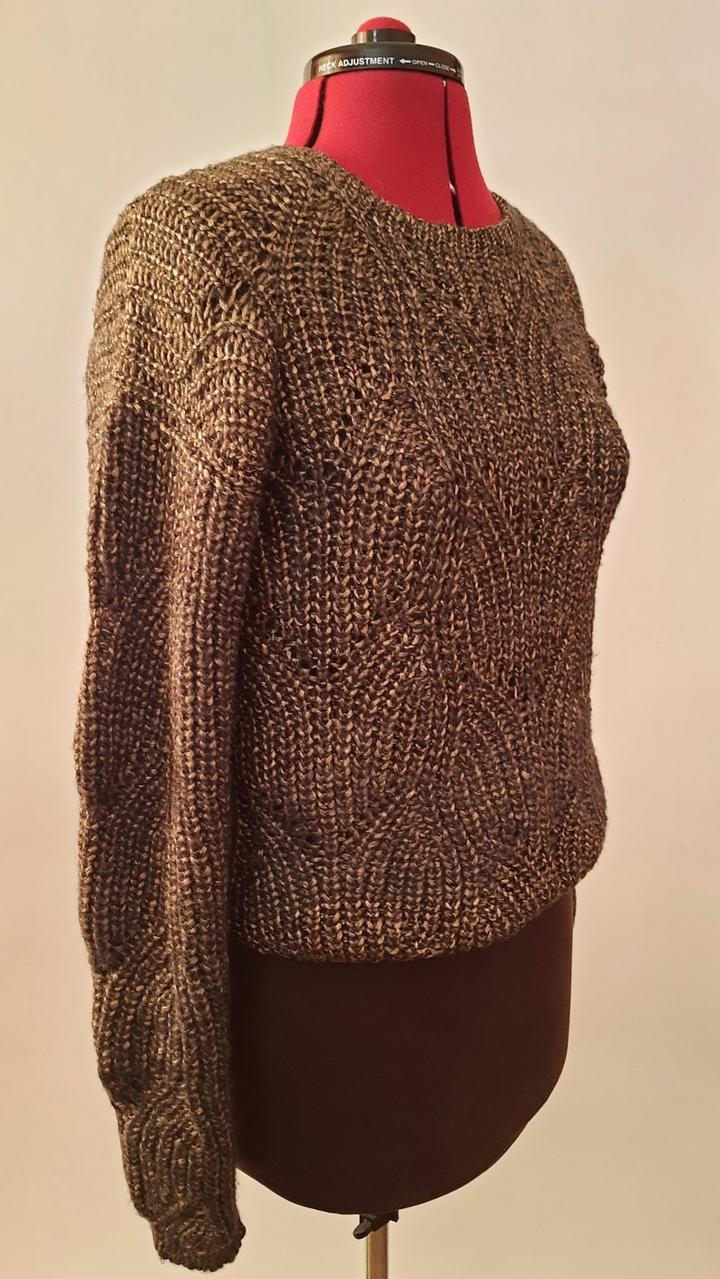 May include: A brown knitted sweater with a textured pattern. The sweater is on a dress form.