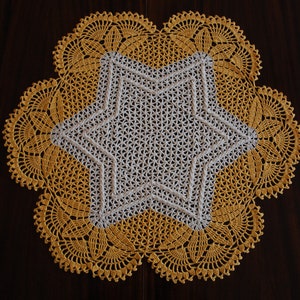 May include: A crocheted doily with a white star in the centre and a yellow border.