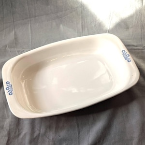 Może przedstawiać: Biała prostokątna forma do pieczenia z niebieskim wzorem kwiatowym po obu stronach.