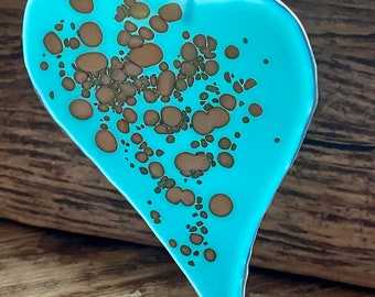 Fused glass heart sun catcher colour changing with light from milky blue to pale milky turquoise with reactive pebble patterns .