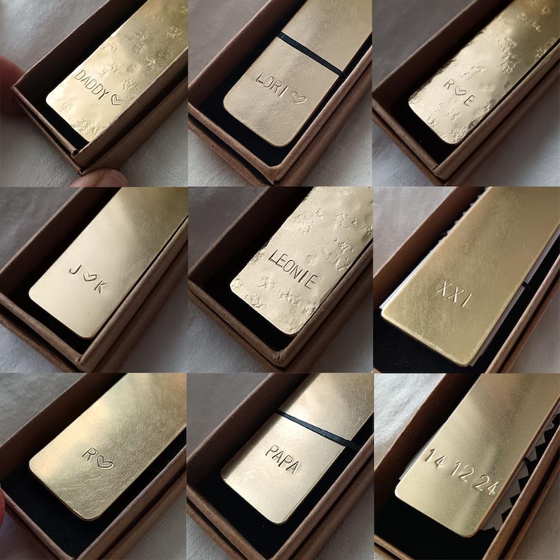 Peut inclure: Une collection de marque-pages rectangulaires en m&eacute;tal dor&eacute;, chacun pr&eacute;sentant des textes ou symboles estamp&eacute;s uniques tels que les noms DADDY, LORI, LEONIE, PAPA, des initiales comme J K, R E, R, le chiffre romain XXI et la date 14 12 24, dans des bo&icirc;tes.