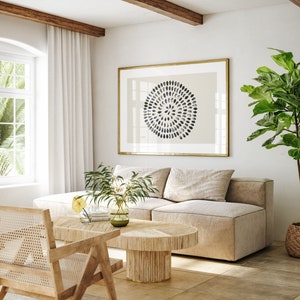 May include: A light beige sectional sofa with a wooden coffee table and a potted plant in the corner. The coffee table has a woven design and a light wood finish. The sofa has a light beige fabric and a modern design. The plant is a fiddle leaf fig with large green leaves.
