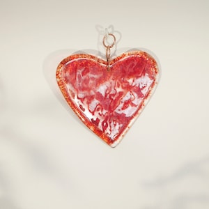 Small suncatcher in the shape of a transparent red heart