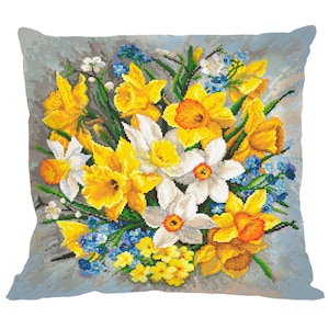 Puede incluir: Una almohada decorativa con un ramo colorido de flores amarillas, blancas y azules. Las flores están dispuestas en un racimo y están rodeadas de hojas verdes. La almohada está hecha de una tela suave y mullida y es perfecta para agregar un toque de primavera a cualquier habitación.