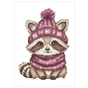 Puede incluir: Un adorable mapache con un gorro de punto rosa con un pompón blanco y una bufanda a juego con copos de nieve blancos. El mapache tiene un pelaje marrón y una nariz negra.