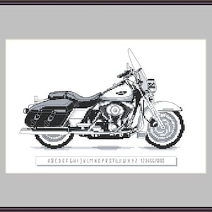 May include: Black and white cross-stitch pattern of a classic motorcycle with a sidecar. The pattern includes a letter and number chart for stitching.