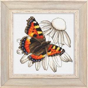 May include: A cross-stitch embroidery of a butterfly with orange, black, and white wings, perched on a white daisy.