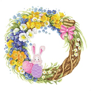 Könnte beinhalten: Ein bunter Osterkranz mit einer braunen Zweigbasis, verziert mit gelben, weißen und blauen Blumen, einer rosa Schleife und einem weißen Hasen, der zwei Ostereier hält.