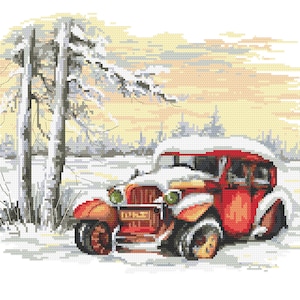 May include: A red vintage car is parked in a snowy winter scene. The car is covered in snow and the background is a snowy forest with a tall tree on the left side of the image.