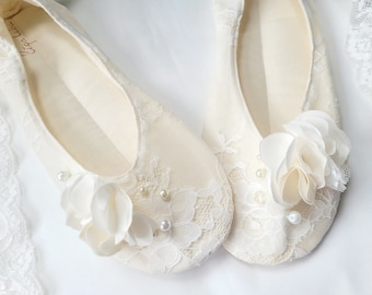Könnte beinhalten: Ein Paar weiße Satin-Brautschuhe mit Spitzendetails und Perlenbesatz. Die Schuhe haben ein zartes Blumenmuster an der Spitze.