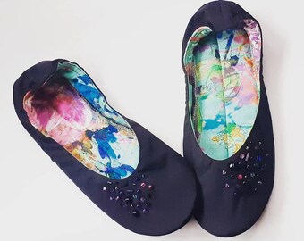 May include: A pair of black ballet flats with floral patterned lining and jeweled embellishments.