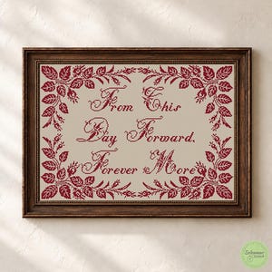 May include: A framed cross-stitch embroidery featuring deep red floral borders and the text "From This Day Forward, Forever More" in a decorative script font, centered on a light beige fabric background within a dark brown wooden frame.