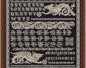 May include: A framed cross-stitch pattern featuring an alphabet and decorative elements in beige on a black background. The design includes ornate borders, stylized dragons, and the text "INSTANT DOWNLOAD PDF". The frame is dark brown.