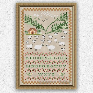 Könnte beinhalten: Kreuzstichmuster mit einem Bauernhaus vor schneebedecktem Bergpanorama, einer Schafherde und einem grünen Wald. Das Muster enthält das Alphabet in grüner und roter Schrift. Das Muster ist in einem braunen Rahmen mit rotem und weißem Rand gerahmt.