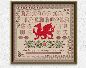 May include: Cross stitch pattern featuring a red Welsh dragon with a green and red floral border. The pattern includes the alphabet in a traditional font. The pattern is framed in a brown frame.
