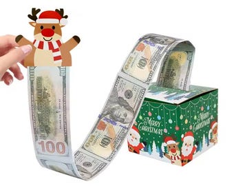 May include: A green cardboard gift box decorated with Santa Claus and reindeer illustrations and the text Merry Christmas. A long strip of connected one hundred dollar bills is attached to a reindeer topper and pulls out of the box.