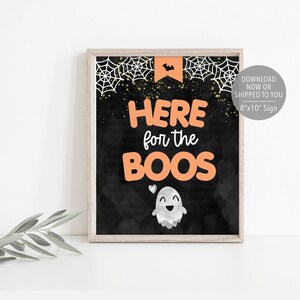 May include: A printable 8x10 inch sign with a black chalkboard background. The sign says "Here for the boos" in orange text with a cute ghost illustration. The sign is perfect for a Halloween party.