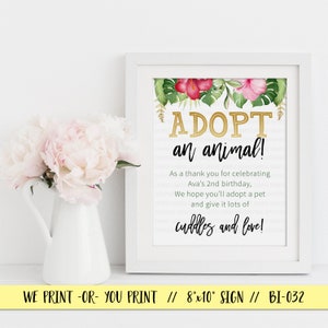 May include: A white framed sign with a tropical floral design and gold text that reads "ADOPT an animal!"  As a thank you for celebrating Ava's 2nd birthday, we hope you'll adopt a pet and give it lots of cuddles and love!  The sign is 8x10 inches.