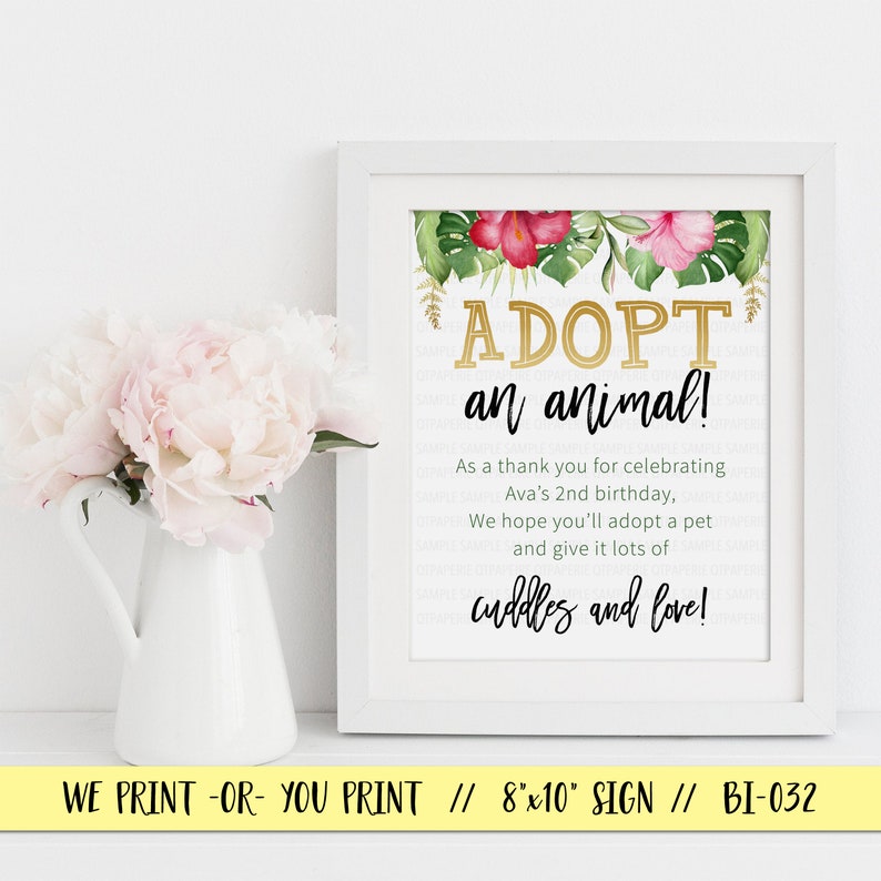 May include: A white framed sign with a tropical floral design and gold text that reads "ADOPT an animal!"  As a thank you for celebrating Ava's 2nd birthday, we hope you'll adopt a pet and give it lots of cuddles and love!  The sign is 8x10 inches.