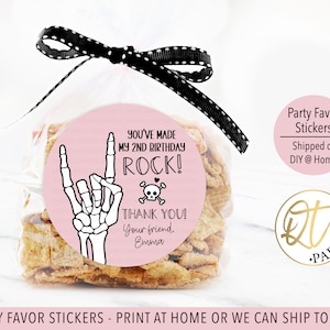 May include: Pink and white round sticker with a skeleton hand making a rock and roll sign. The sticker says "You've made my 2nd birthday rock!" and "Thank you! Your friend, Emma".