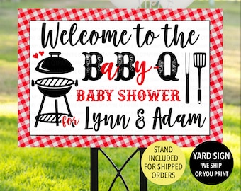 May include: Red and white checkered welcome sign for a baby shower. The sign says "Welcome to the Baby-Q Baby Shower for Lynn & Adam". There is a black and white grill and grilling utensils on the sign.