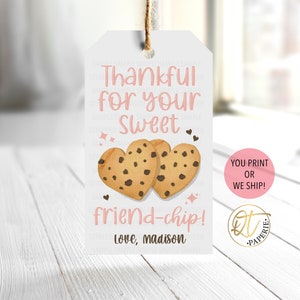 May include: A white gift tag with pink text that reads "Thankful for your Sweet friend-chip! Love, madison". Two chocolate chip cookies in the shape of hearts are pictured above the text. The tag has a pink circle with the text "YOU PRINT OR WE SHIP!" in white text. A gold circle with the text "QT PAPERIE" is in the bottom right corner.