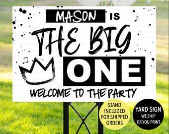 May include: Black and white yard sign with the text "MASON IS THE BIG ONE WELCOME TO THE PARTY". The sign has a crown and musical notes. The sign is on a black metal stand.