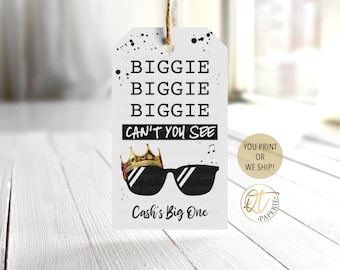 May include: Black and white printable tag with the text "BIGGIE BIGGIE BIGGIE CAN'T YOU SEE" and a crown and sunglasses graphic. The text "Cash's Big One" is at the bottom of the tag.