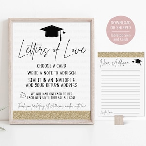 May include: A framed sign with the text "Letters of Love" and instructions for writing notes. A notepad with lines and a graduation cap graphic is also shown. The sign has a gold glitter border.