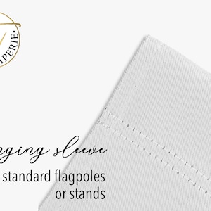 Pode incluir: Manga suspensa de tecido branco com bordas costuradas. O texto "Hanging sleeve" est&aacute; escrito em it&aacute;lico, com o texto "Fits standard flagpoles or stands" abaixo. Um logotipo dourado est&aacute; no canto superior esquerdo.