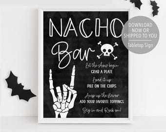Puede incluir: Un letrero de "Nacho Bar" en blanco y negro enmarcado con una calavera y huesos cruzados, una mano de esqueleto e instrucciones. El letrero incluye el texto "Descargar ahora o enviado a usted" y es un letrero de mesa.