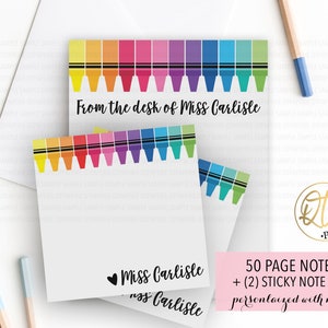 May include: A set of personalized teacher stationery featuring a colorful crayon border with the text "From the desk of Miss Carlisle". The set includes a 50-page notepad and two sticky note pads.