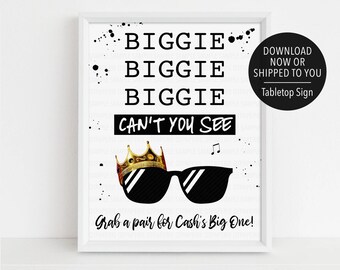 Könnte beinhalten: Ein schwarz-weißes druckbares Schild mit dem Text "BIGGIE BIGGIE BIGGIE CAN'T YOU SEE" und einer Grafik von einer Sonnenbrille mit einer Krone oben drauf. Der Text "Grab a pair for Cash's Big One!" befindet sich am unteren Rand des Schildes.
