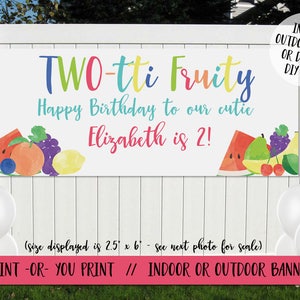 May include: A colorful banner with the text "TWO-tti Fruity Happy Birthday to our cutie Elizabeth is 2!" and a watercolor illustration of fruit. The banner is 2.5 feet by 6 feet and is available as a digital file or printed banner.