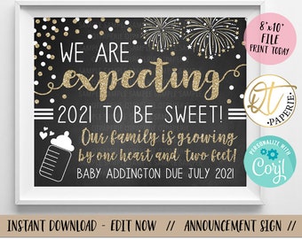 May include: Black chalkboard style sign with gold glitter text announcing "We are expecting 2021 to be sweet!" with a baby bottle graphic and the text "Our family is growing by one heart and two feet! Baby Addington due July 2021".